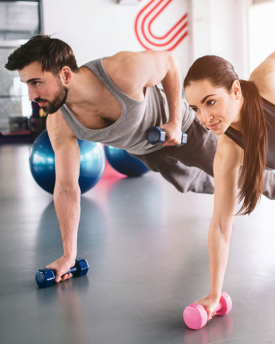 Mann und Frau beim Fitnesstraining mit Hanteln