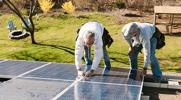 zwei Personen arbeiten im Garten an der Solaranlage