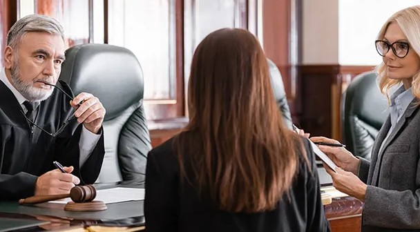 Anwälte und Klientin besprechen im Gerichtssaal