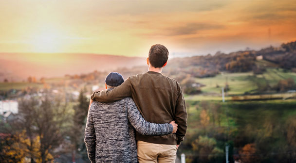 Vater und Sohn blicken in die Ferne - Sonnenuntergangstimmung