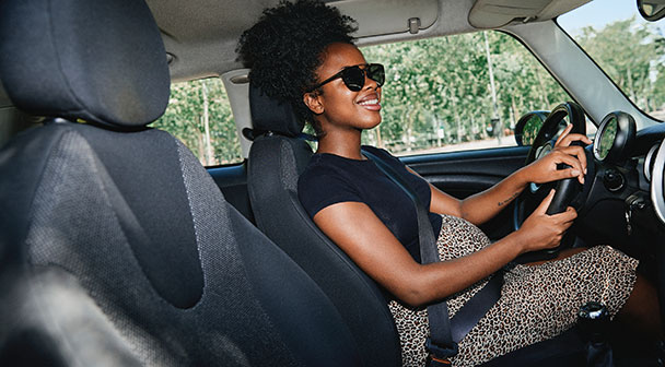 Fröhliche Frau beim Auto fahren