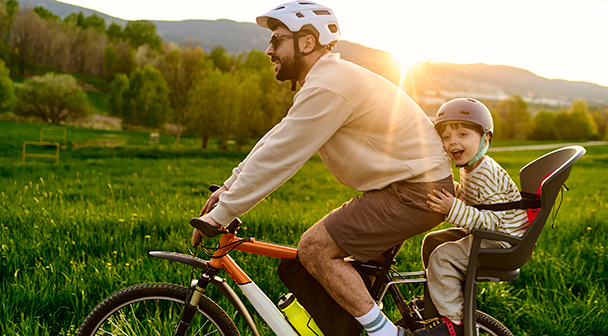 Vater und Kind mit dem Fahrrad in der Abendsonne unterwegs