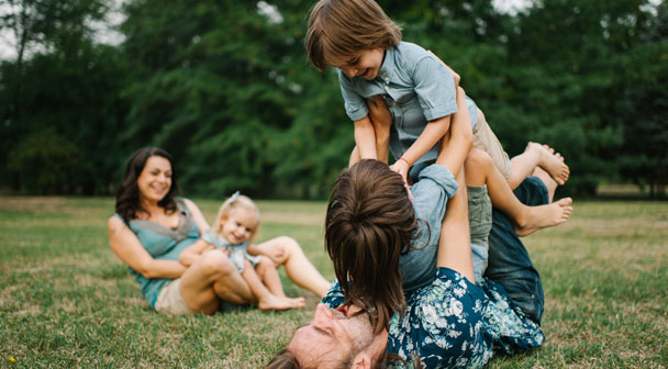 Familie spielt mit ihren Kindern im Grünen