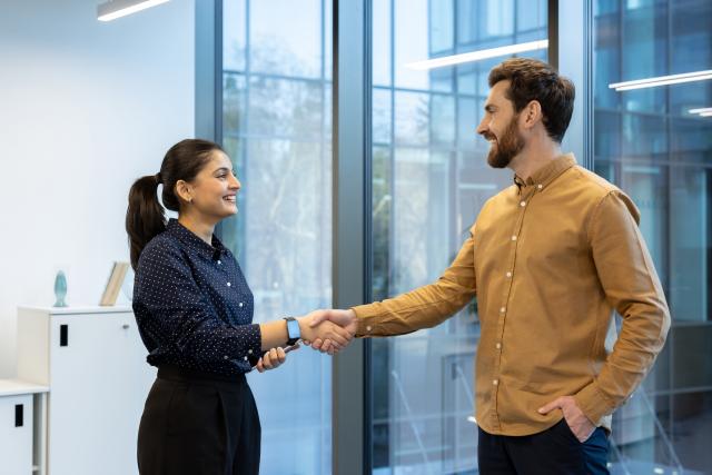 two_people_shaking_hands_in_office