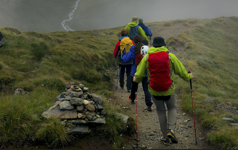 Kleingruppe Wanderer marschiert bei nebligem Wetter durch die Berge