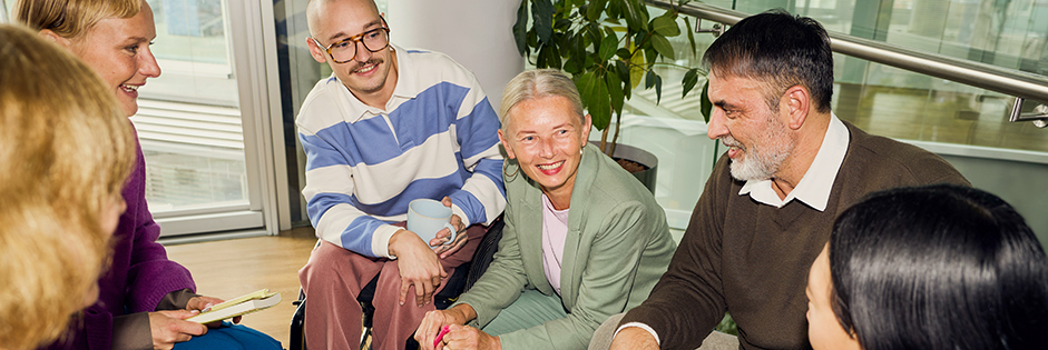 Gruppe von Menschen sitzt zusammen und tauscht sich aus