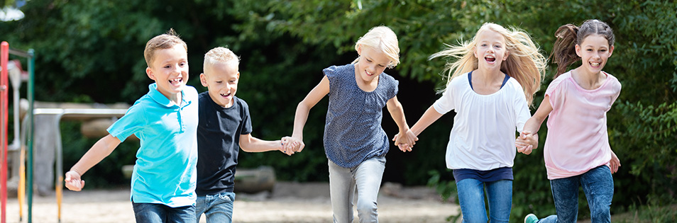 Kinder halten sich an den Händen und laufen