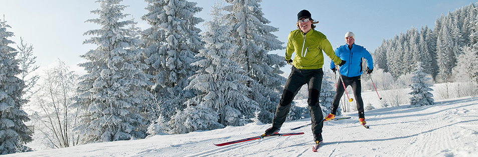 Paar beim Langlauf in verschneiter Landschaft