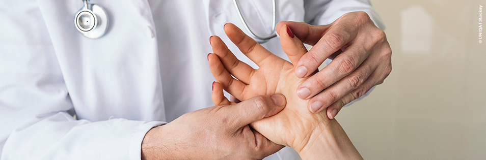 Arzt untersucht die Hand von einer Patientin