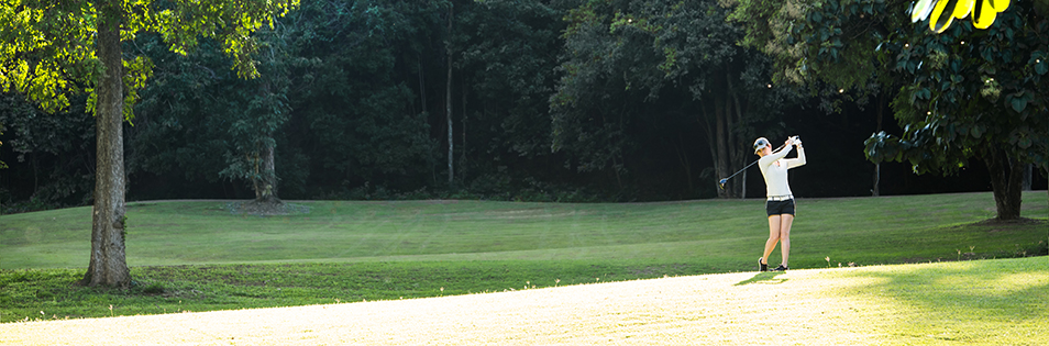 Frau beim Golf schlägt ab