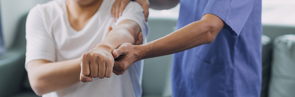 Therapeut macht Bewegungsübung mit Patient