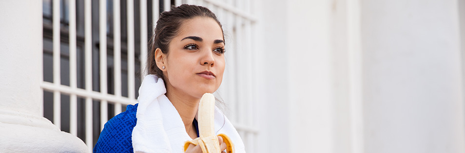 Frau isst eine Banane nach dem Training