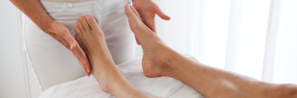 Therapeutische Anwendung an den Füßen im Rahmen einer kinesiologischen Behandlung.