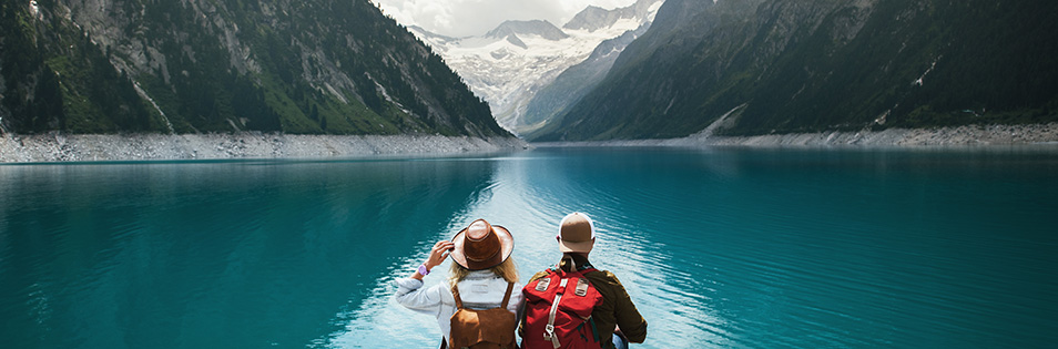 Wanderer am See begutachten einen entfernten Gletscher