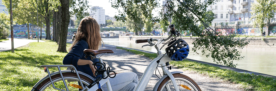 Mit dem E-Bike am Donaukanal - Radfahrerin macht eine Pause