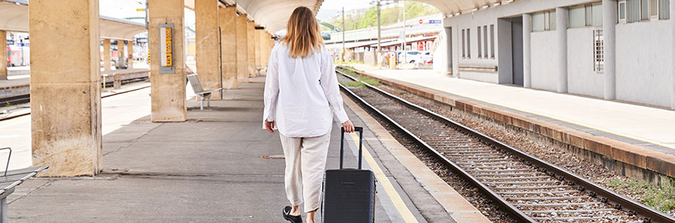 Frau am Bahnhof wartet auf den Zug