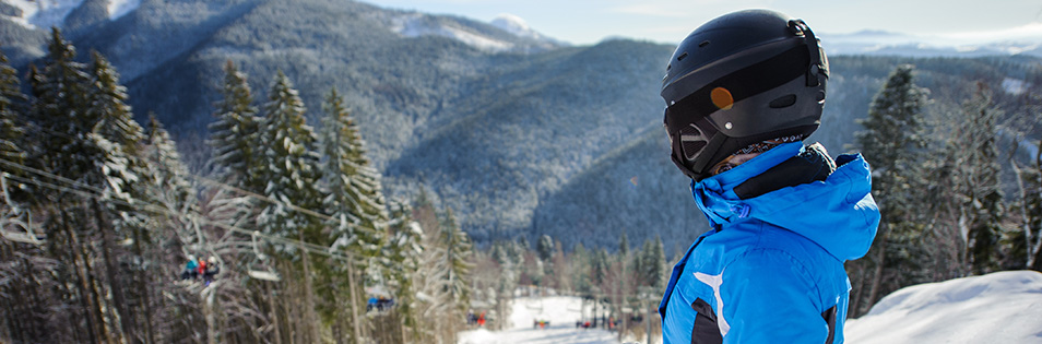 Skifahrer am Berg schaut in die verschneite Landschaft