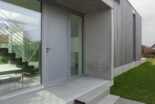 Graue Aluminiumhaustür mit Glasfront an modernem Haus in München