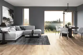 Gemütliches Wohnzimmer mit rahmenlosen Fenstern und klarer Aussicht ins Grüne