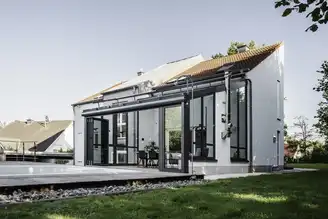 Moderner Wohnwintergarten mit geöffneter Glas-Faltwand und Blick auf den Pool