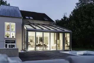 Wohnwintergarten bei Dämmerung mit Innenbeleuchtung