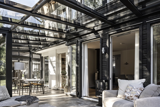 Detailaufnahme eines Wohnwintergartens mit geöffnetem Schiebeelement und Glasdach