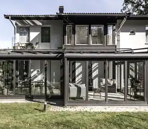 Moderner Wohnwintergarten mit Glasfassade und verschatteter Dachkonstruktion