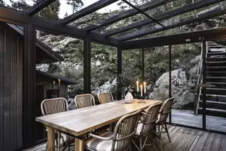 Wohnwintergarten mit Essbereich und Ausblick auf Felslandschaft