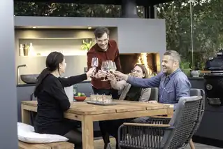 Gruppe von Freunden beim Abendessen im Wohnwintergarten