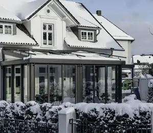 Wohnwintergarten im Winter mit Schneelast auf dem Glasdach