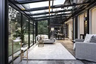 Innenansicht eines Wohnwintergartens mit Sofa und Pflanzen