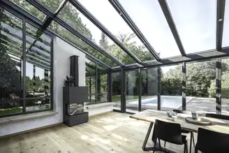 Wohnwintergarten mit Blick auf Terrasse und Pool