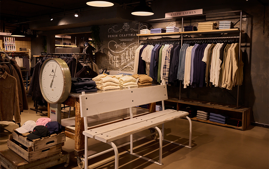 Interieur van The Bakery by OFM. in Reusel. Bankje in de winkel met daarachter kledingrekken