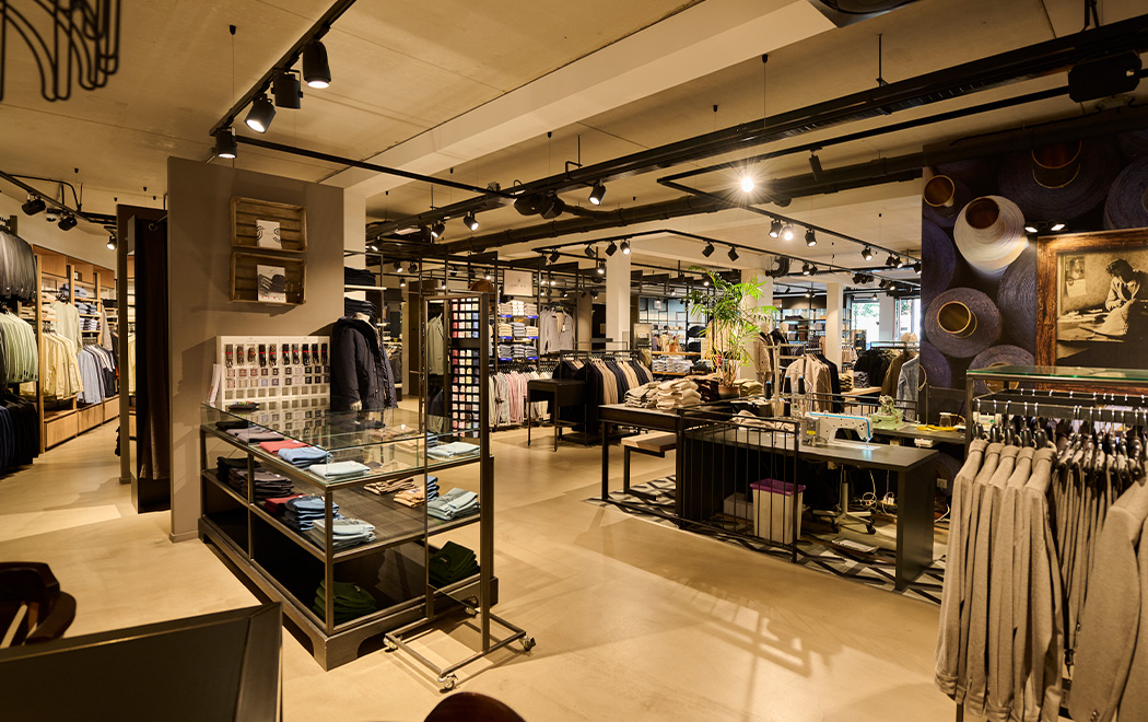 Overzichtsfoto van binnenkant van OFM. Reusel. Kledingrekken en stapels kleding