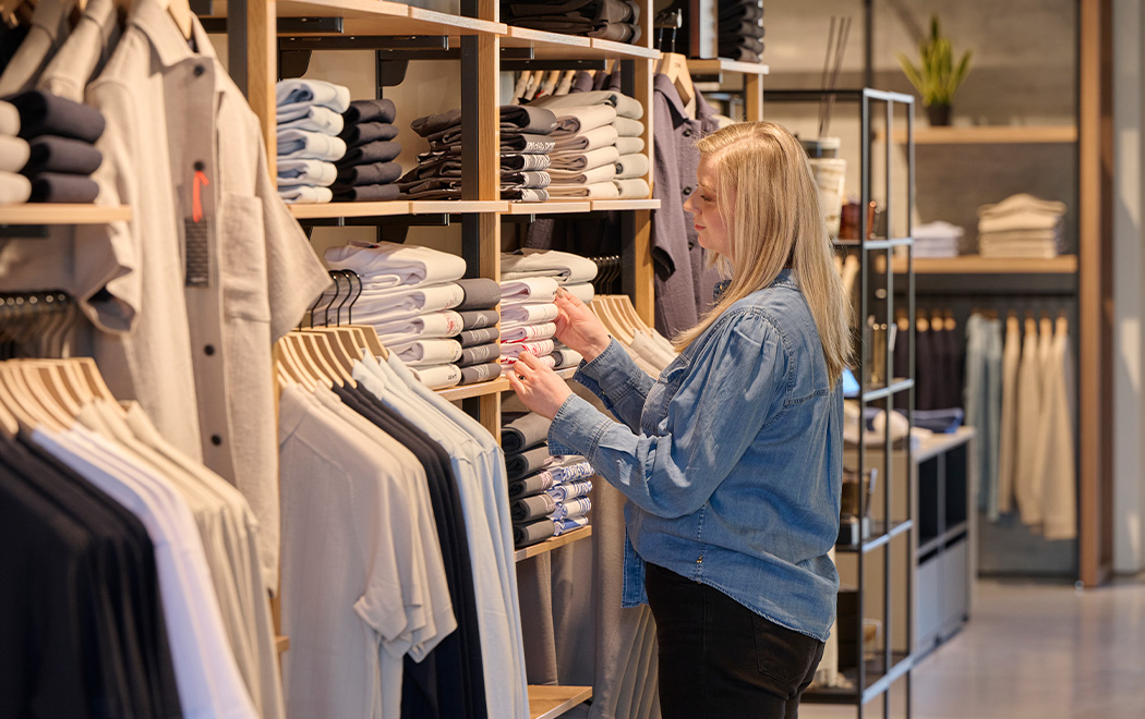 Mederwerker OFM. Doesburg vouwt kleding op