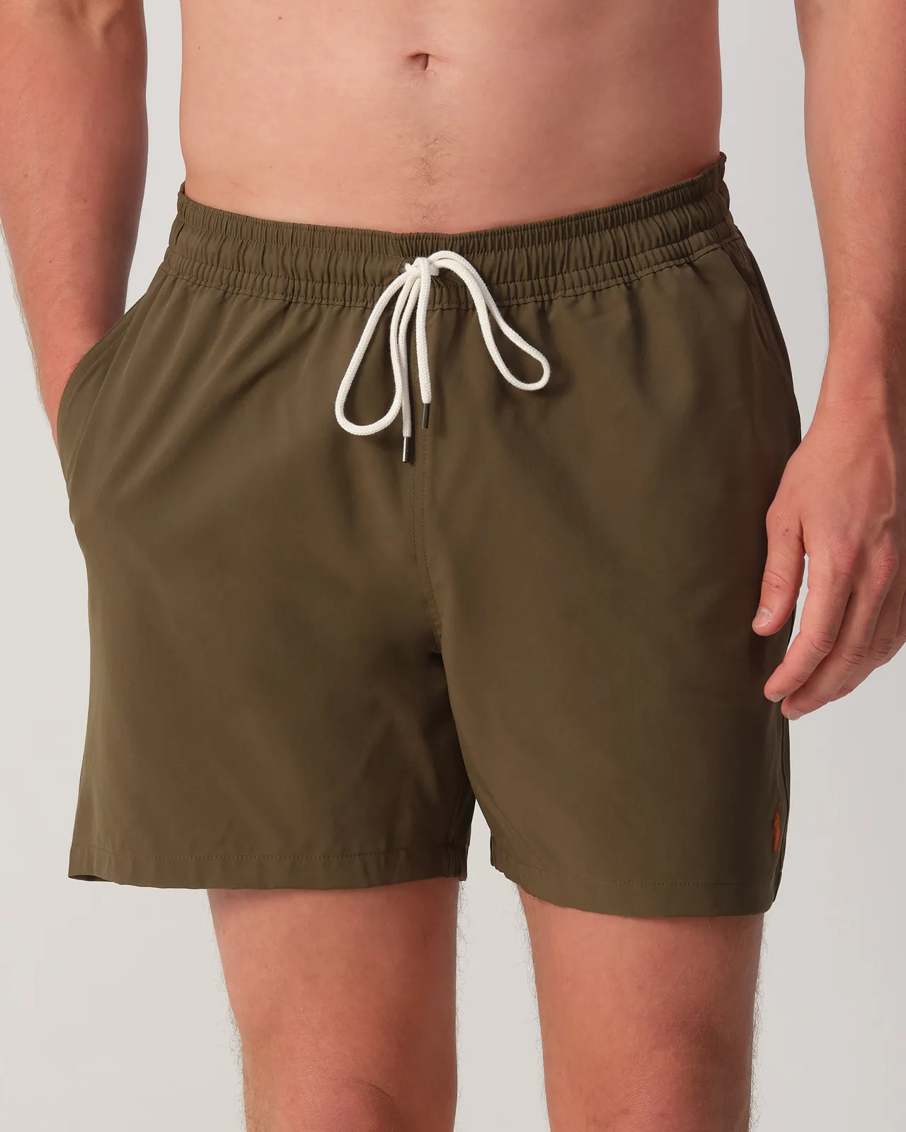 Man draag een groene zwembroek van Ralph Lauren.