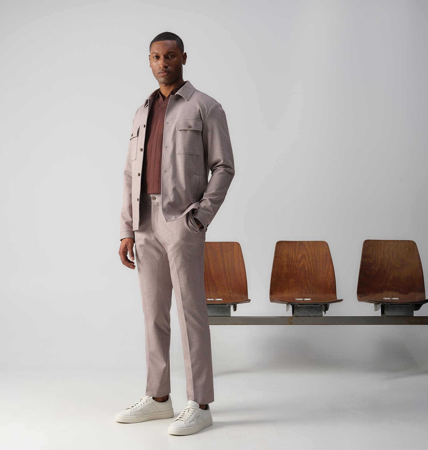 Man poserend voor een rij met stoelen