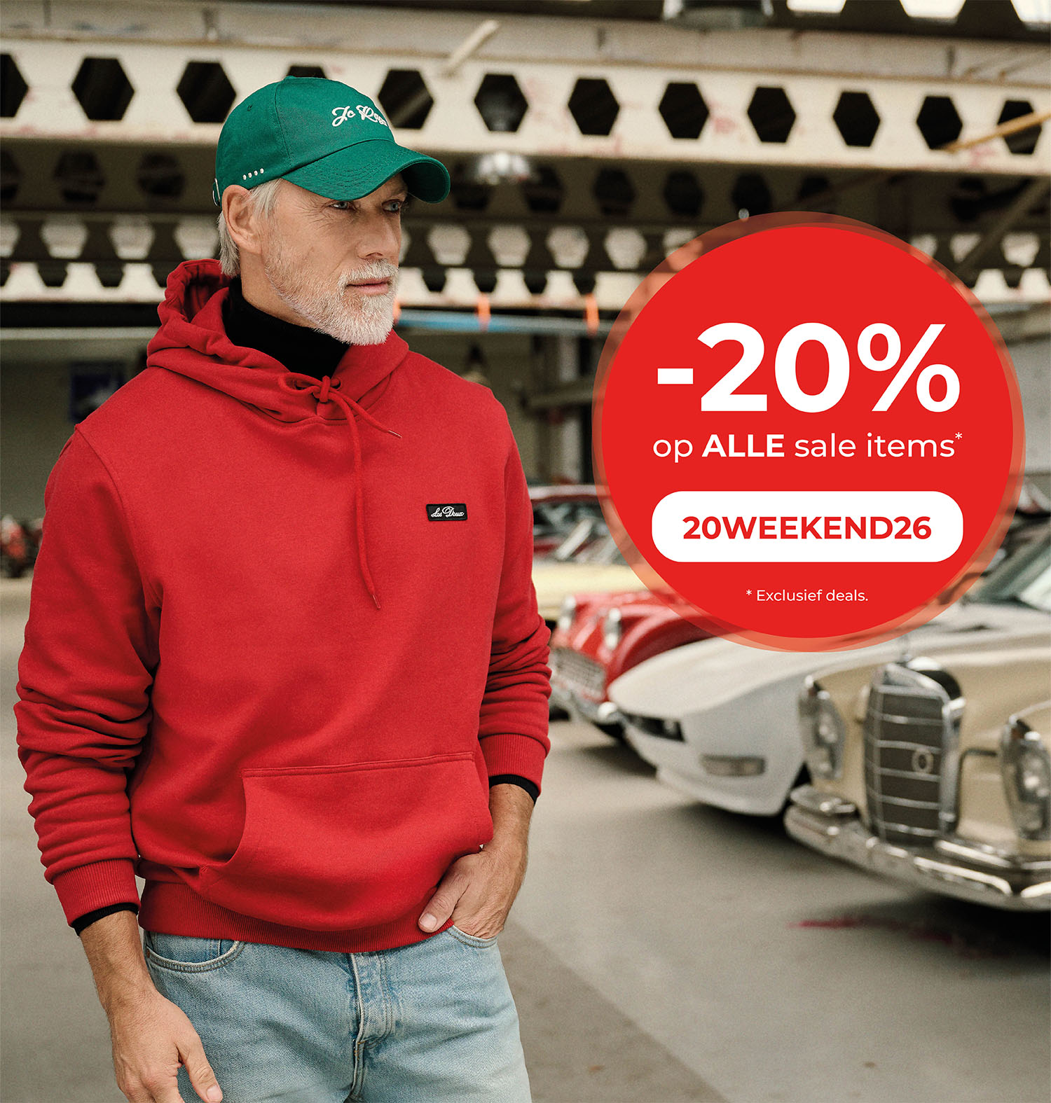 -20% op alle sale items. 20WEEKEND26. *Exclusief deals. Herobanner. Model met rode hoodie en groene pet in een garage