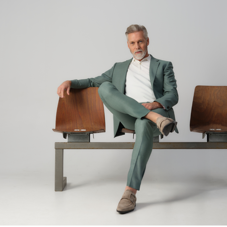 man in groen pak zittend op gymzaal stoelen