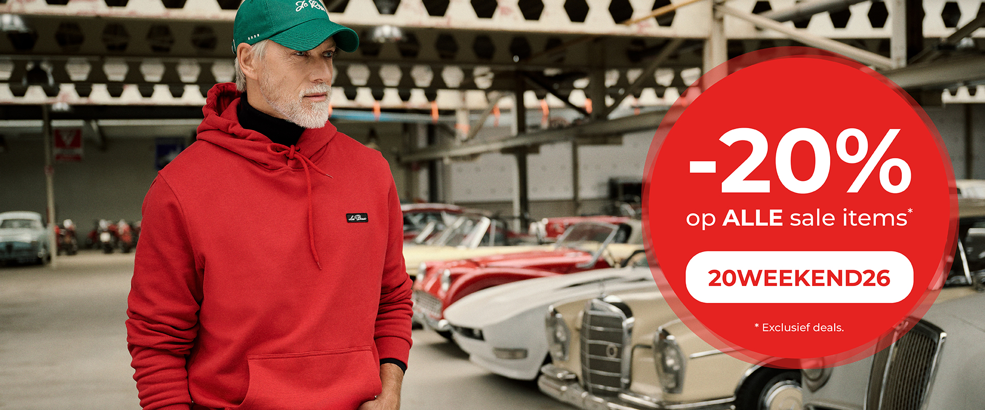 -20% op alle sale items. 20WEEKEND26. *Exclusief deals. Herobanner. Model met rode hoodie en groene pet in een garage