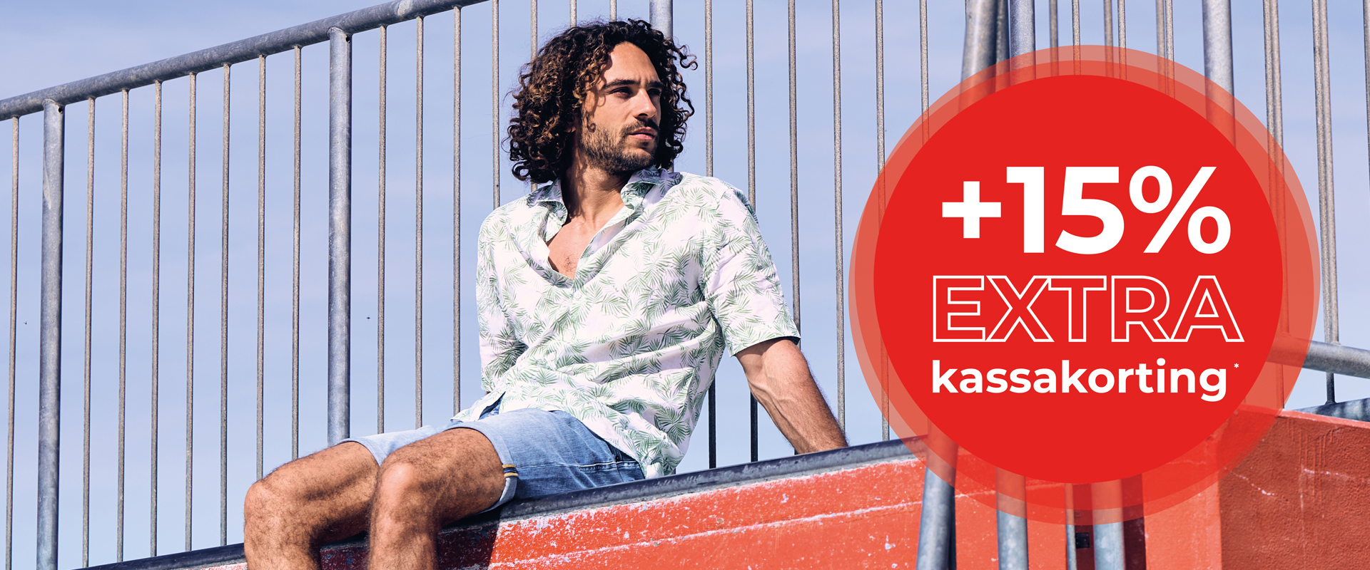 Man in a floral shirt and denim shorts sitting on a railing next to a red text circle offering 15% extra discount.
