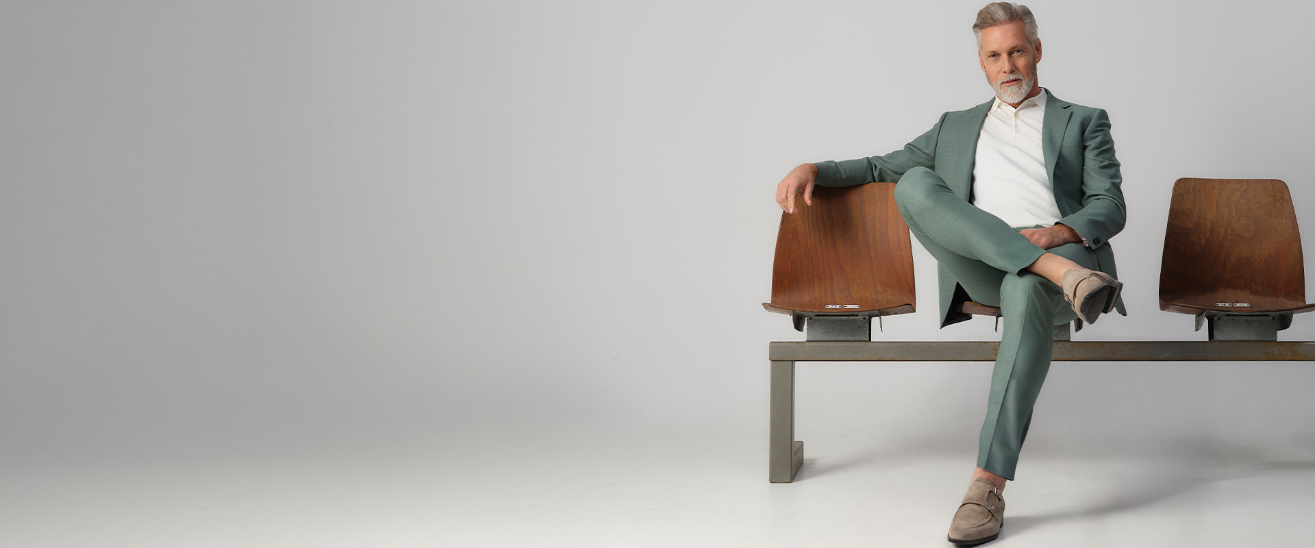 man zittend in een groen pak op gym stoelen