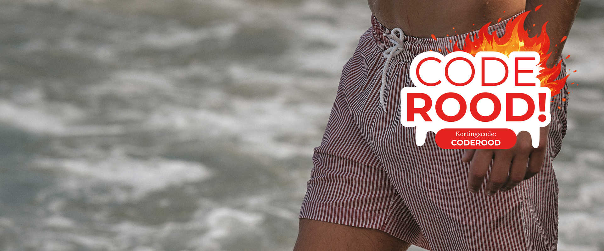 Person in striped shorts near the ocean with a "Code Rood!" warning sign in front, designed with flames.