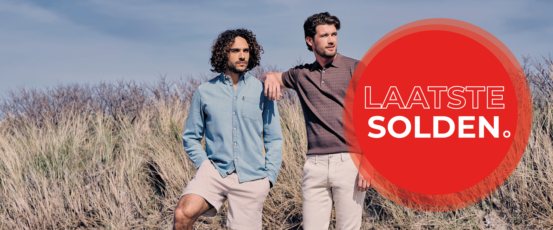 Two men in casual shirts stand in a scenic field. A red circle on the right contains the Dutch text "LAATSTE SOLDEN."