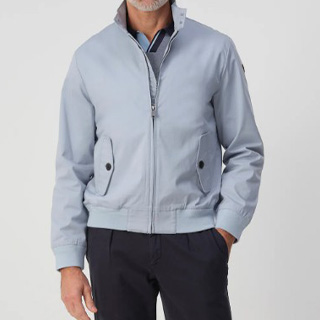 afbeelding van een man met een licht blauw/grijze zomerjas aan