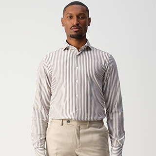 Man wearing a striped shirt and beige pants, standing against a plain white background.