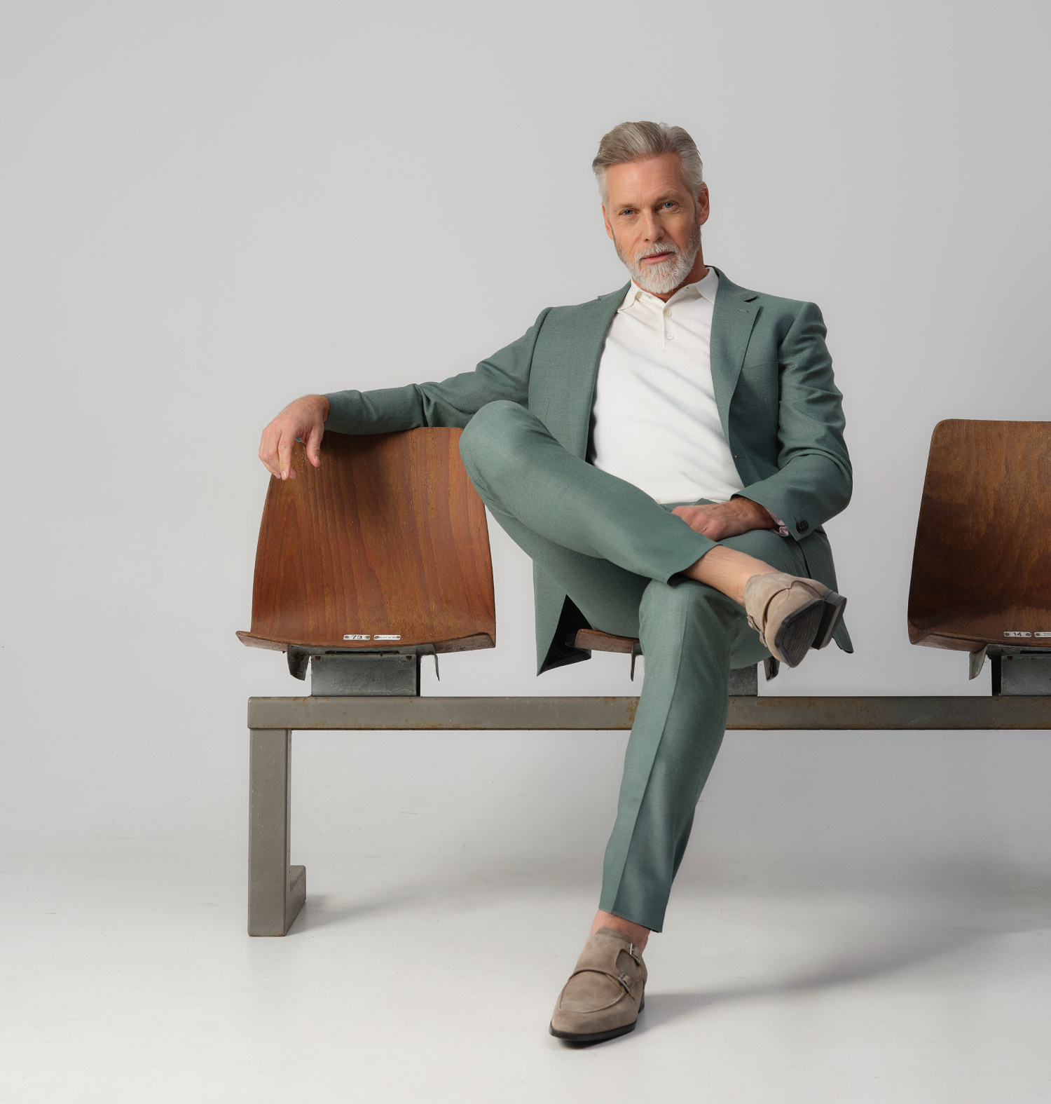 man zittend in een groen pak op gym stoelen