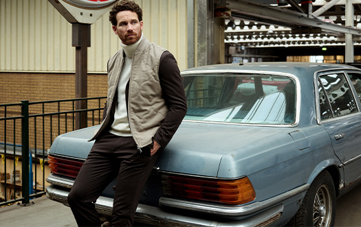 man hangend tegen een auto