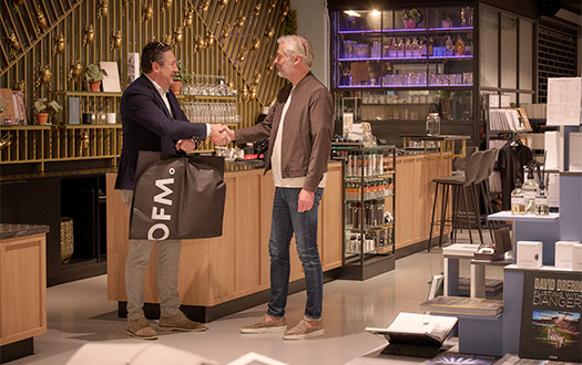 Man die een pak heeft afgerekend bij OFM. Alkmaar en daarom de handschud met de verkoper.