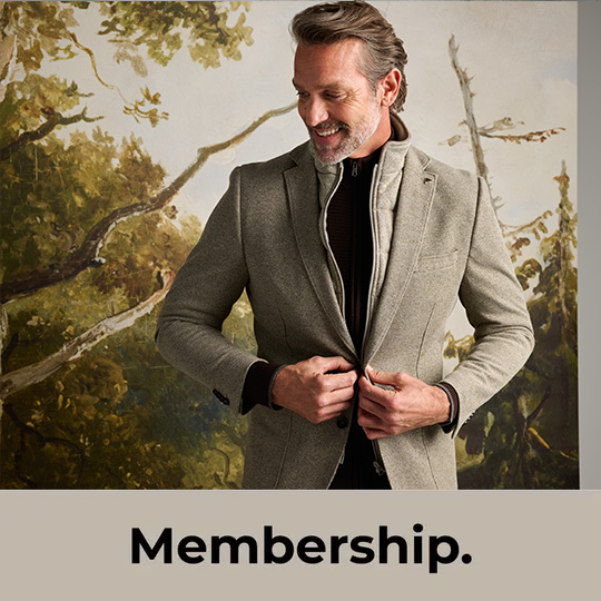 Membership. OFM. Club. Model poserend in een winterjas met herfstachtig achtergrond